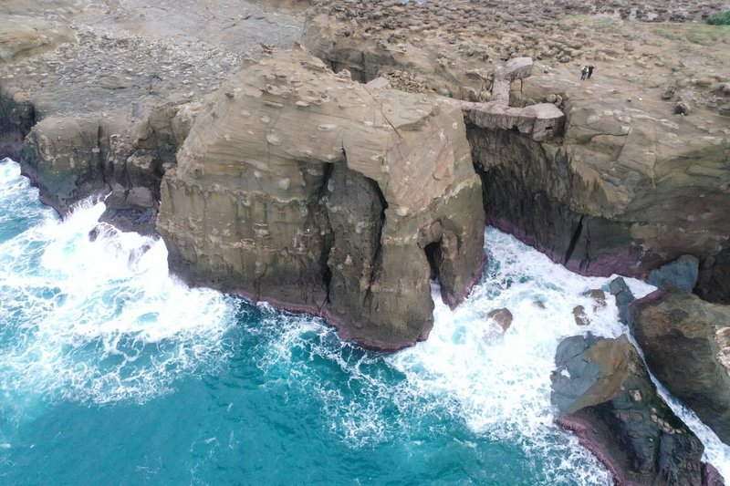 東北角著名景點「象鼻岩」日前因岩石自然風化、海水長期侵蝕等因素導致「象鼻」在強浪拍打下斷裂落海，招牌「象鼻」景觀不再。圖為瑞芳區龍鎮里長林文清透過空拍機捕捉「斷鼻」後的岩體現況。（林文清提供）中央社記者黃旭昇新北市傳真  112年12月23日