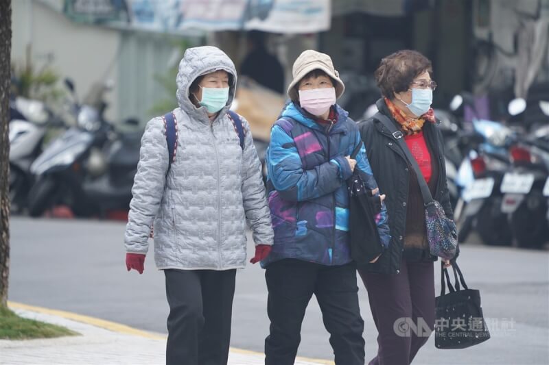 圖為台北市北投區民眾穿上外套禦寒。（中央社檔案照片）