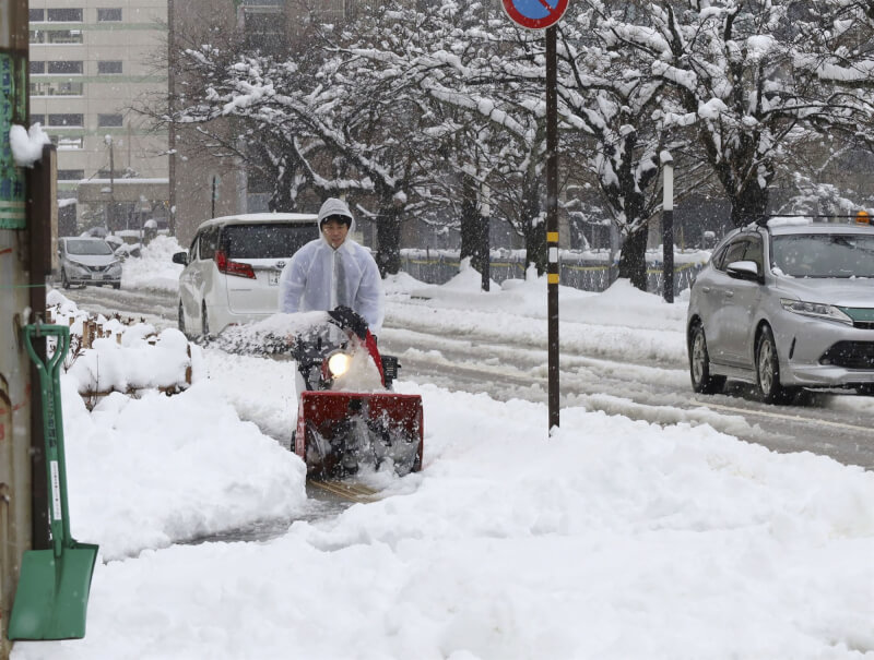 強烈寒流侵襲，日本海側的北日本到西日本降大雪。圖為福井市民22日在街上剷除積雪。（共同社）