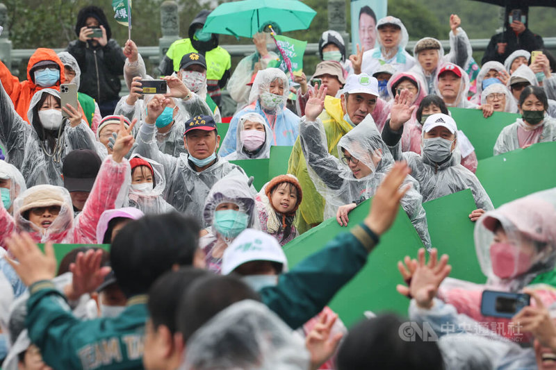 民進黨總統候選人賴清德（綠衣，背對揮手者）環島拼圖「唱土地的歌，拼咱的希望」活動，24日上午來到桃園明倫三聖宮，許多支持者冒雨熱情相挺。中央社記者裴禛攝 112年12月24日