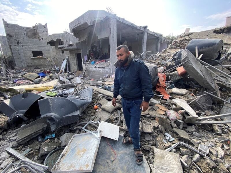 加薩中部馬加齊24日深夜遭以色列空襲，死傷慘重，失去親人的巴勒斯坦男子25日神情哀傷地站在難民營廢墟中。（路透社）