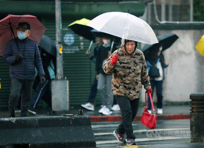 圖為台北市區民眾撐傘擋雨。（中央社檔案照片）