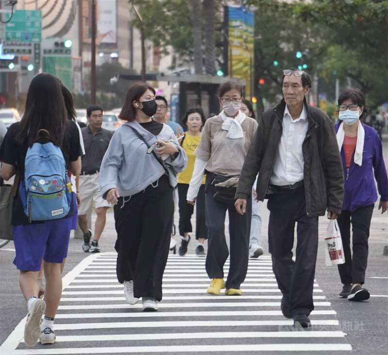 圖為高雄市新興區街頭午後民眾穿起薄長袖外衣。（中央社檔案照片）