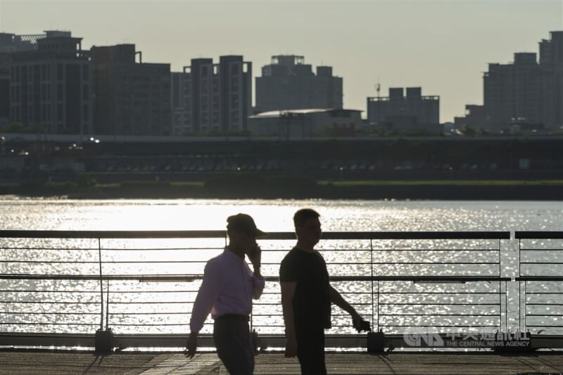 圖為夏季民眾在台北大稻埕碼頭散步，豔陽反射在河面上波光粼粼。（中央社檔案照片）