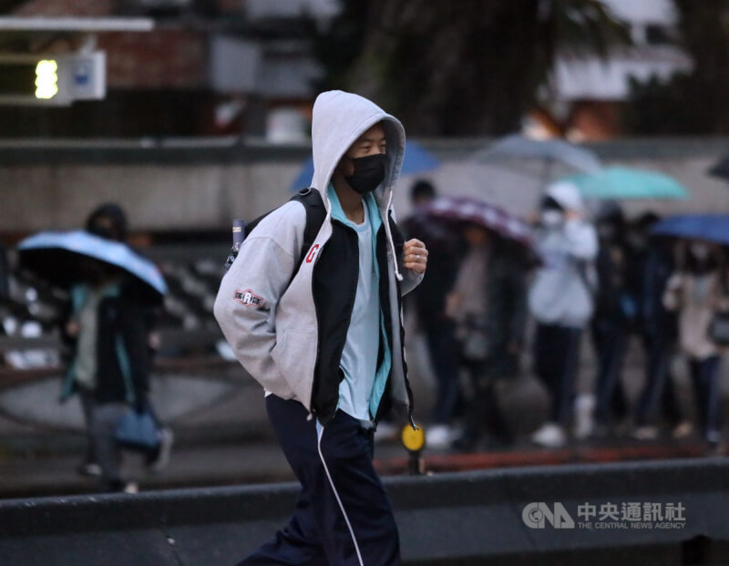 圖為台北市區傍晚時刻細雨加上低溫，街頭民眾穿起厚外套防寒。（中央社檔案照片）