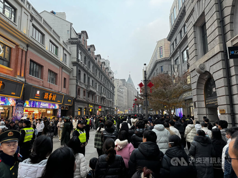 31日上海南京路步行街人潮太多，警察與武警出動維持秩序，除了沿路廣播提醒注意事項外，並以人牆將不同方向的民眾區隔。中央社記者吳柏緯上海攝  112年12月31日