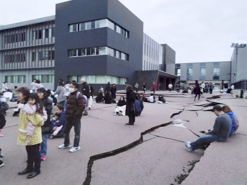 石川縣輪島市一處地面在強震後毀損，許多民眾到戶外避難。（共同社）