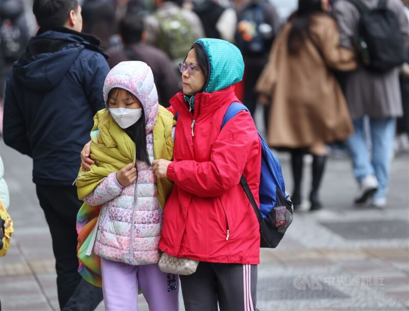 圖為台北市大安區街頭的民眾穿外套、戴帽子禦寒。（中央社檔案照片）