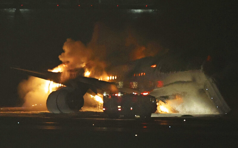 日本航空一架班機2日降落在羽田機場時疑似擦撞海上保安廳的飛機，在跑道上起火燃燒。機場表示，這架日航班機無法放下輪胎降落，而是以機腹著地。（共同社）