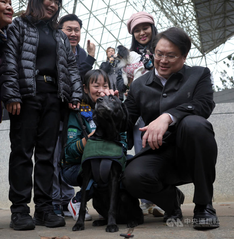內政部長林右昌（前右）4日下午在台北大安森林公園出席「我愛毛孩公益嘉年華」活動，與防疫犬互動、合影。中央社記者王飛華攝  113年1月4日
