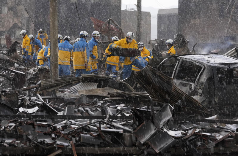 地震重創日本能登半島，石川縣輪島市警方6日在雨中進行清理搜救。（共同社）