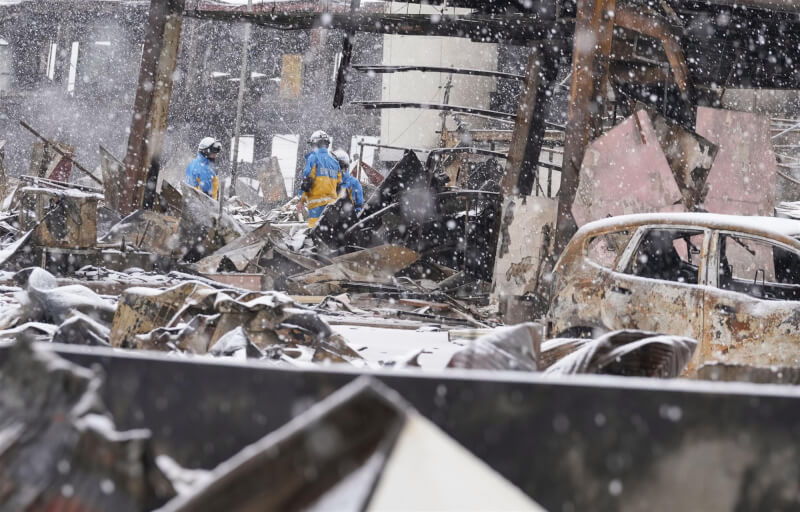 7日石川縣輪島市已開始積雪，救難人員在輪島朝市進行救災工作。（共同社）