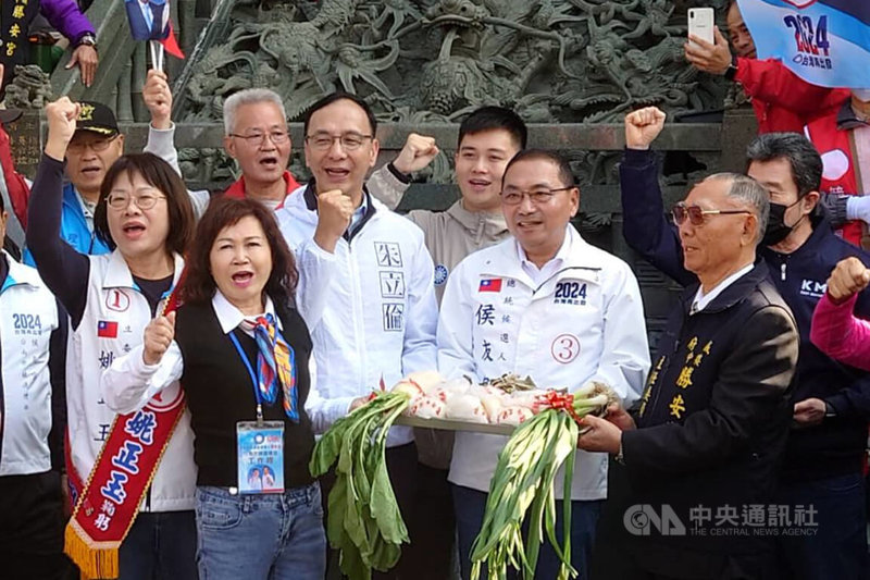 國民黨總統候選人侯友宜（前右2）8日在台南市展開車隊掃街行程，與第3選區立委候選人姚正玉（2排左1）、黨主席朱立倫（2排左2）從北區中樓勝安宮出發，廟方及支持者特別送上預祝勝選的吉祥物。中央社記者楊思瑞攝 113年1月8日