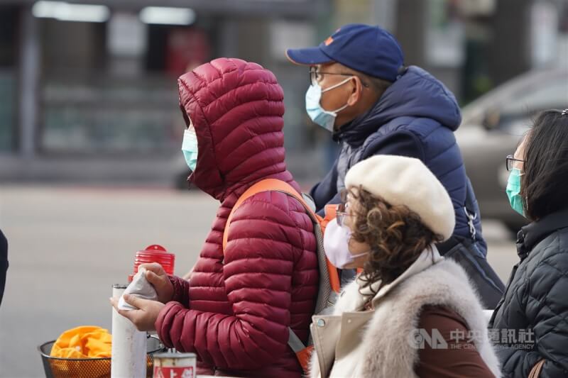 圖為民眾穿著禦寒衣物在台北市中山區街頭等紅燈。（中央社檔案照片）