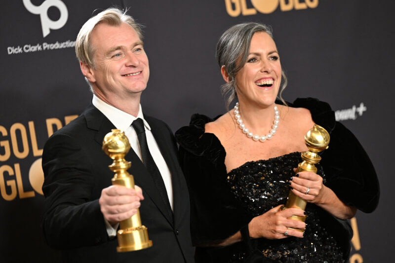 電影「奧本海默」奪下第81屆金球獎劇情類最佳影片，導演克里斯多福諾蘭（左）與製片艾瑪湯瑪斯奪獎後合影。（法新社）