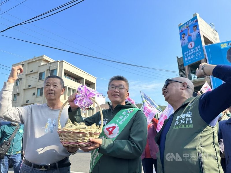 選戰進入倒數，爭取連任的民進黨立委蔡其昌（中）9日進行車隊掃街拜票，獲得支持者贈送象徵「包中」的粽子表達祝福。中央社記者趙麗妍攝  113年1月9日