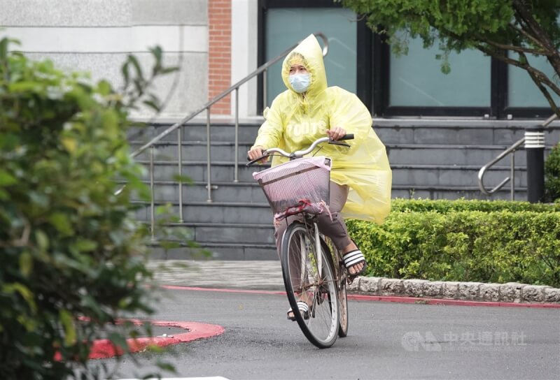 圖為台北市南港區民眾穿著雨衣騎單車。（中央社檔案照片）