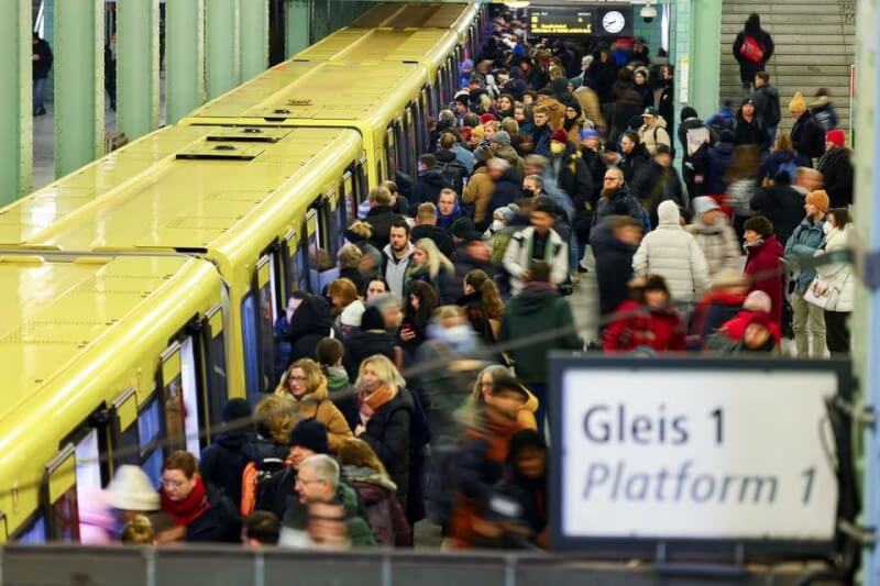 德國鐵路工人展開大罷工，通勤民眾面臨各地火車班次取消狀況。圖為乘客10日在亞歷山大廣場站車廂旁行走。（路透社）