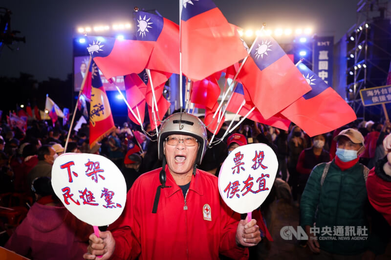 國民黨選前之夜造勢晚會，民眾頭戴插滿國旗的安全帽，並舉起自製標語看板到場力挺。中央社記者吳家昇攝 113年1月12日