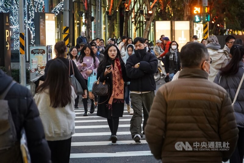圖為台北市信義區民眾穿起厚外套、圍巾保暖。（中央社檔案照片）