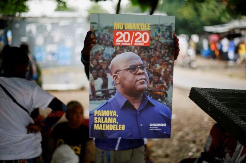 圖為剛果一名支持者拿著印有總統齊塞克迪頭像的海報（路透社）