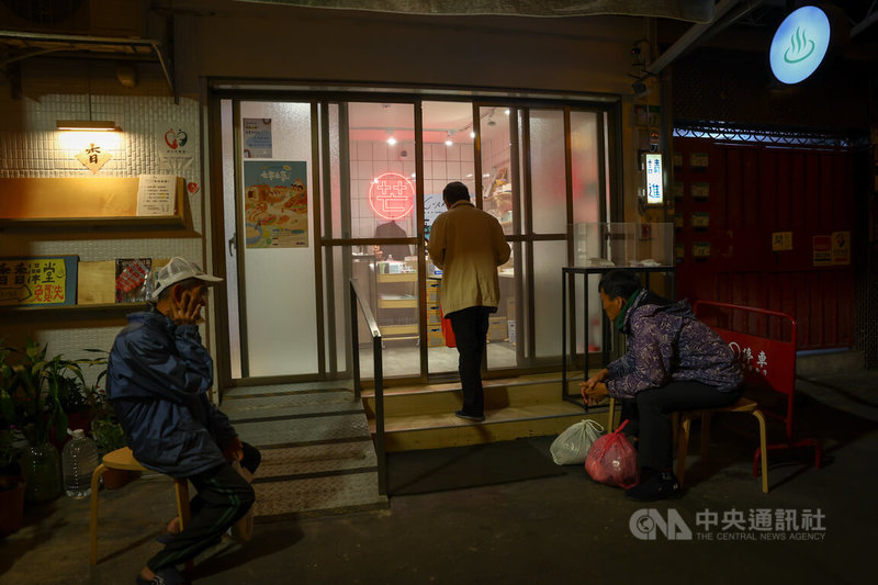 香香澡堂門口高掛圓形招牌，門口澡客三三兩兩，或坐或站閒聊中。中央社記者王騰毅攝 113年1月20日