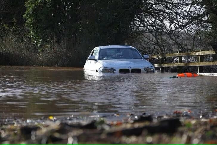 鄰近蘇格蘭的英格蘭北部地區風雨成災，22日可見路邊車輛泡在水中。（路透社）