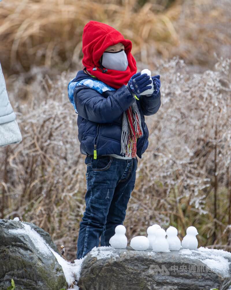不少民眾帶著孩子上山追雪,有小朋友穿著厚外套戴上連帽圍巾保暖,開心堆雪人。中央社記者鄭清元攝 113年1月23日