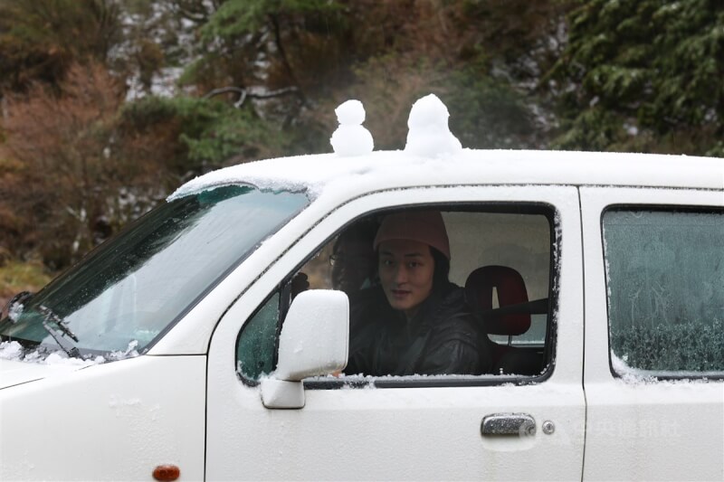 有民眾在車頂堆雪人應景,模樣逗趣。中央社記者王騰毅攝 113年1月23日