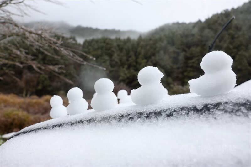 思源埡口山區降雪，有民眾在車前堆起雪鴨應景。中央社記者王騰毅攝 113年1月23日