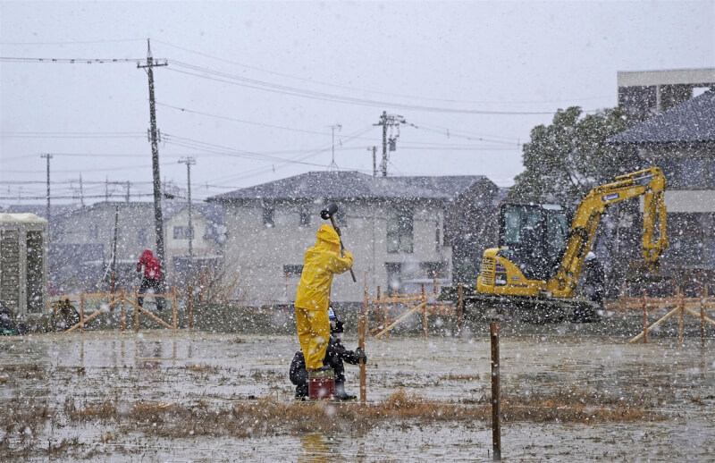 圖為石川縣七尾市，工人在大雪中進行臨時住宅建設工程。（共同社）