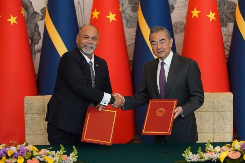 中國外交部長王毅（右）與諾魯外交部長安格明（左）24日簽署復交聯合公報，恢復大使級外交關係，正式復交。（Andrea Verdelli/Pool via 路透社）