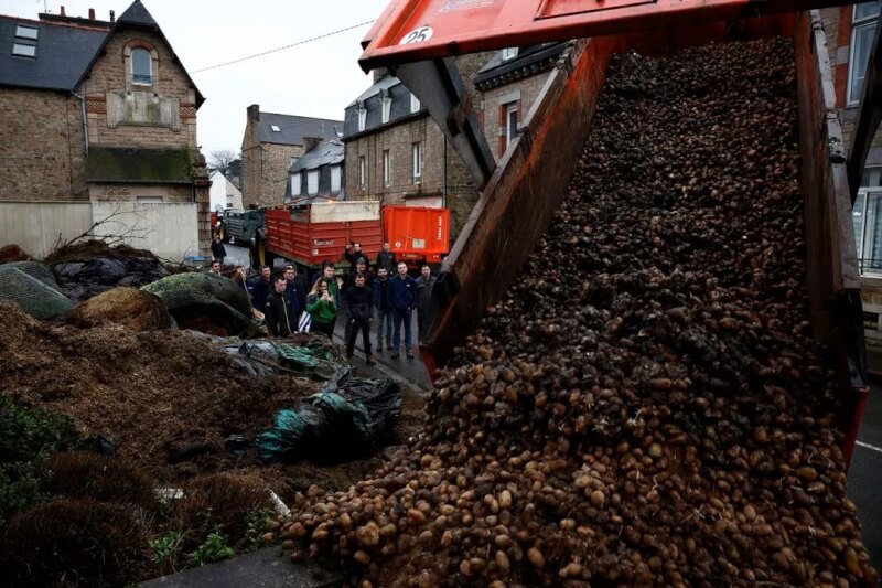 法國布列塔尼地區農民24日在路上傾倒馬鈴薯及垃圾，表達對政府政策的不滿。（路透社）