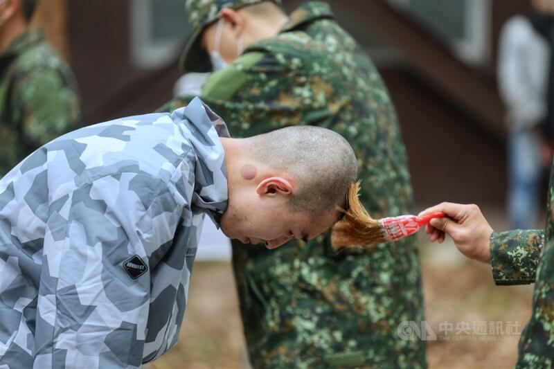俗稱「髮婆」的理髮小姐持電推剪髮器替役男理頭髮,並由新訓幹部以油漆刷替役男上痱子粉。中央社記者王飛華攝 113年1月25日