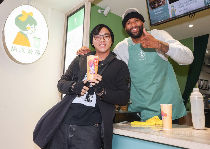 效力台灣職籃T1聯盟台啤永豐雲豹的前美國職籃NBA球星卡森斯(DeMarcus Cousins)(右)受邀擔任手搖飲一日店長,限量100杯「表弟奶茶」特別請藝術家Jeff(左)設計杯身小貼圖,看到成品的卡森斯相當滿意。中央社記者張新偉攝 113年1月26日