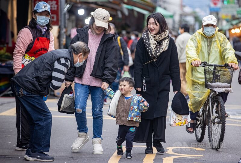 圖為民眾帶小朋友到台北市木新市場，穿上保暖衣物禦寒。（中央社檔案照片）