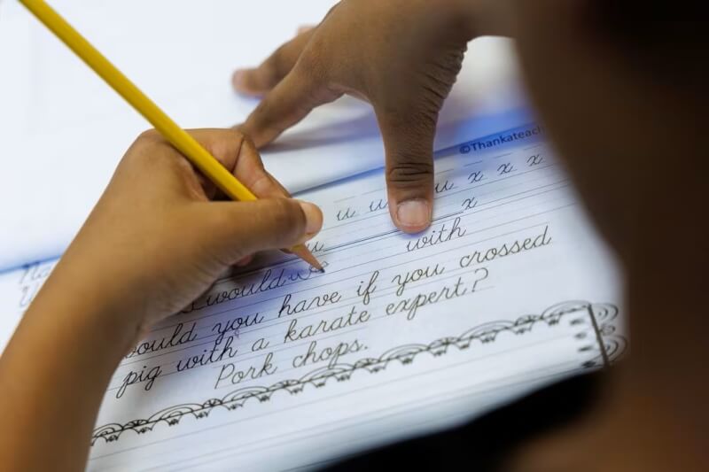 加州奧蘭治索普國小一名學生23日正在練習書寫體。（路透社）