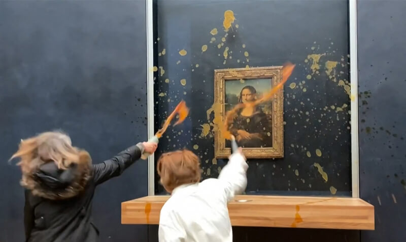 兩名抗議人士28日在法國羅浮宮博物館，朝受防彈玻璃保護的鎮館之寶「蒙娜麗莎」畫像潑灑湯汁。（法新社）