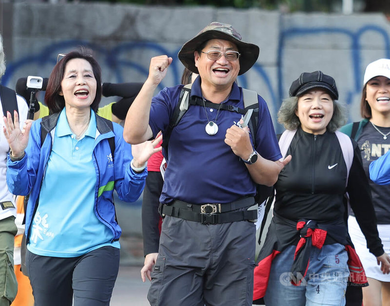 台師大在職專班學生詹章誾（前中）月初展開徒步環島，預計每走1公里捐贈新台幣100元，盼拋磚引玉幫助清寒學子，31日傍晚回到台師大校門口，振臂和前來歡迎他的師長、同學們致意。中央社記者謝佳璋攝  113年1月31日