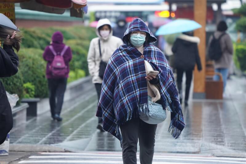 圖為台北市中山區民眾披著毛毯禦寒。（中央社檔案照片）