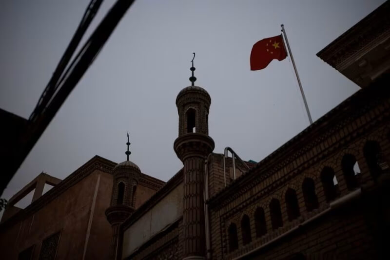圖為2021年5月新疆喀什市一間清真寺懸掛五星旗。（路透社）