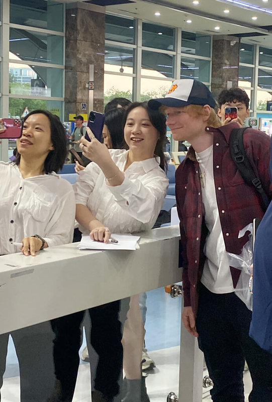 英國創作歌手紅髮艾德(Ed Sheeran)(右)1日搭乘包機抵達高雄小港機場,與前來接機的粉絲自拍合影。(讀者提供)中央社記者葉冠吟傳真 113年2月2日