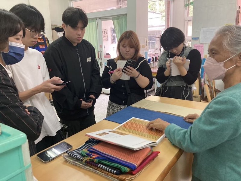 日本神戶工科藝術大學學生日前到屏東參訪傳統工藝保存者許春美(右)的工作坊,許春美向他們介紹排灣族傳統服飾的製作過程,以及織紋和圖樣都是傳達族人生活智慧與文化內涵的載體。(高雄市原住民事務委員會提供)中央社記者張已亷傳真 113年2月5日