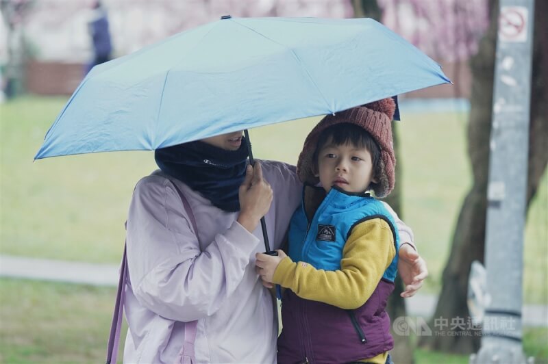 圖為台北市內湖區，民眾為小朋友戴上帽子禦寒、撐傘遮雨。中央社記者徐肇昌攝 113年2月6日