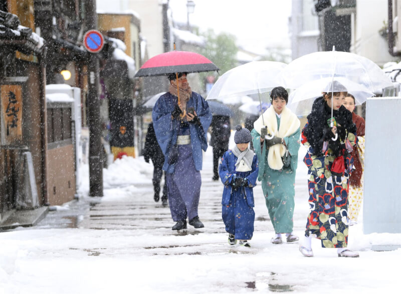 圖為去年12月雪中的金澤市民眾。（共同社）