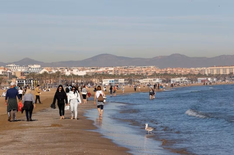 圖為西班牙民眾1月25日漫步在瓦倫西亞的海灘。（路透社）