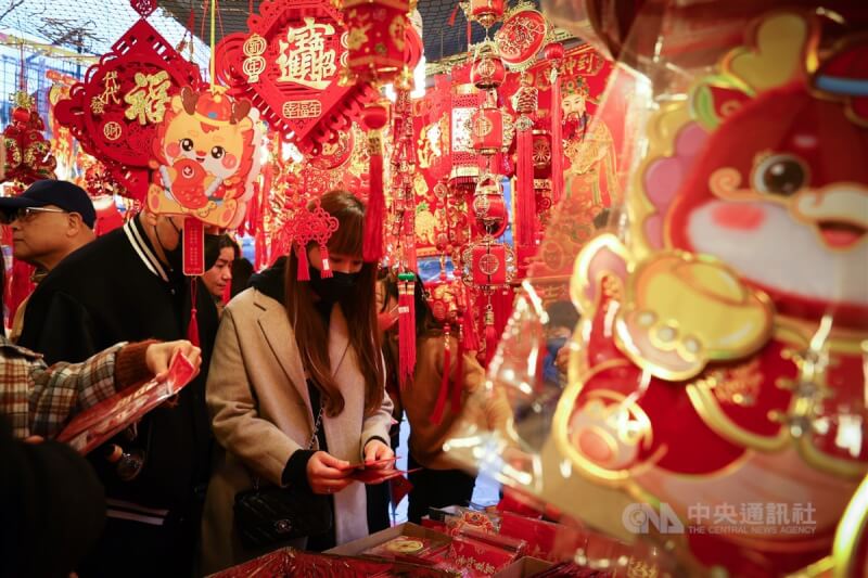 圖為民眾到台北市迪化街年貨大街商圈選購應景春聯、紅包等飾品。（中央社檔案照片）