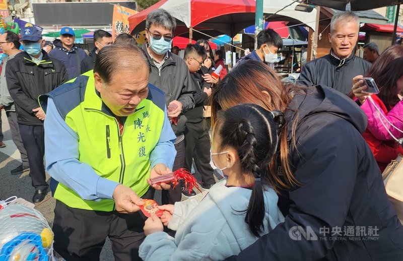 澎湖馬公城隍廟春節一條街市集10日登場，澎湖縣長陳光復（前左）到場向民眾拜年，並發放龍年福袋。中央社  113年2月10日