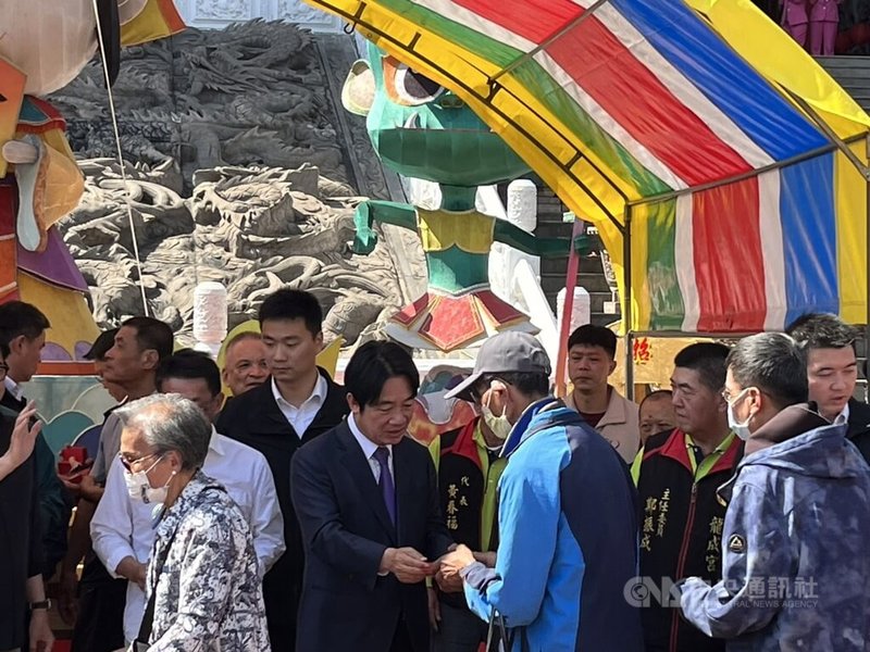 總統當選人賴清德（穿西裝者）14日至高雄鳳山五甲龍成宮參香並發放福袋，為加快發放速度，過程採取不拍照、不握手等方式。中央社記者林巧璉攝  113年2月14日