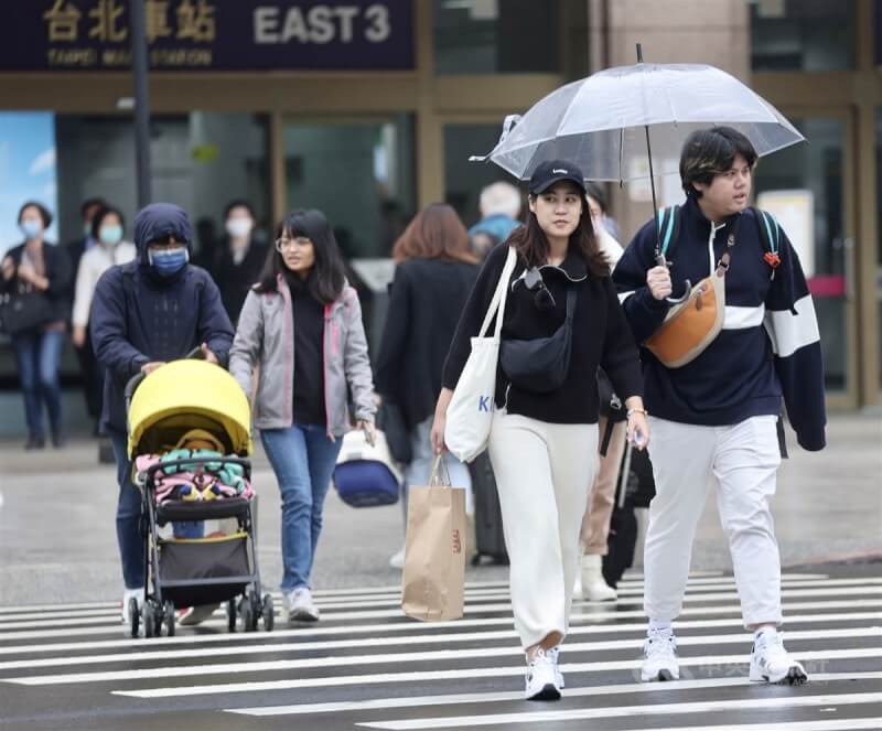 圖為民眾在台北車站附近撐傘過馬路。（中央社檔案照片）